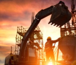 Silhouette Teams of Business Engineers looking for blueprints in construction sites through blurry construction sites at sunset.