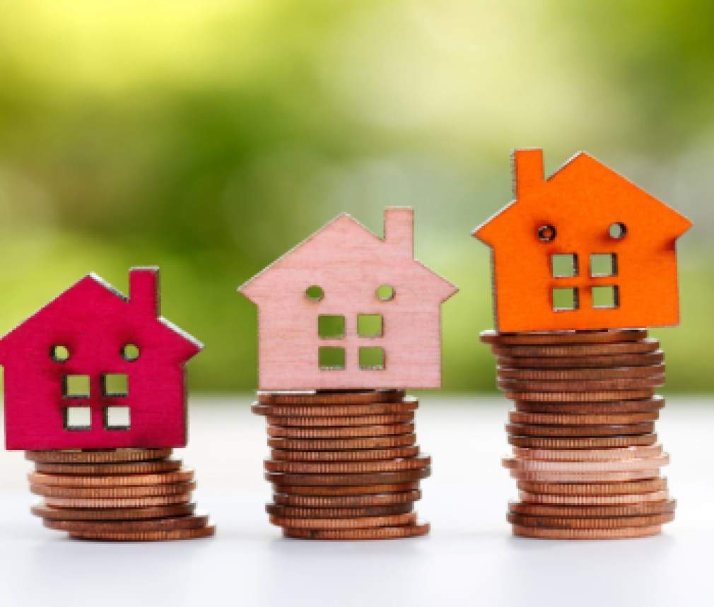 Wooden house model on coins stack. Property, Finance, investment and growth in business concept.