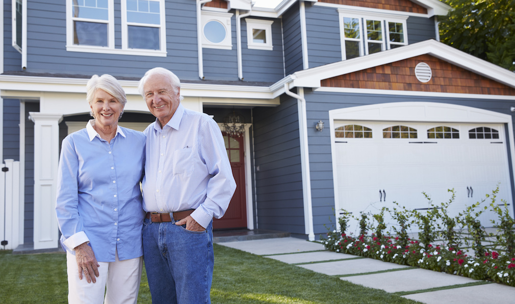 Portrait Of Senior Couple Standing Outside House