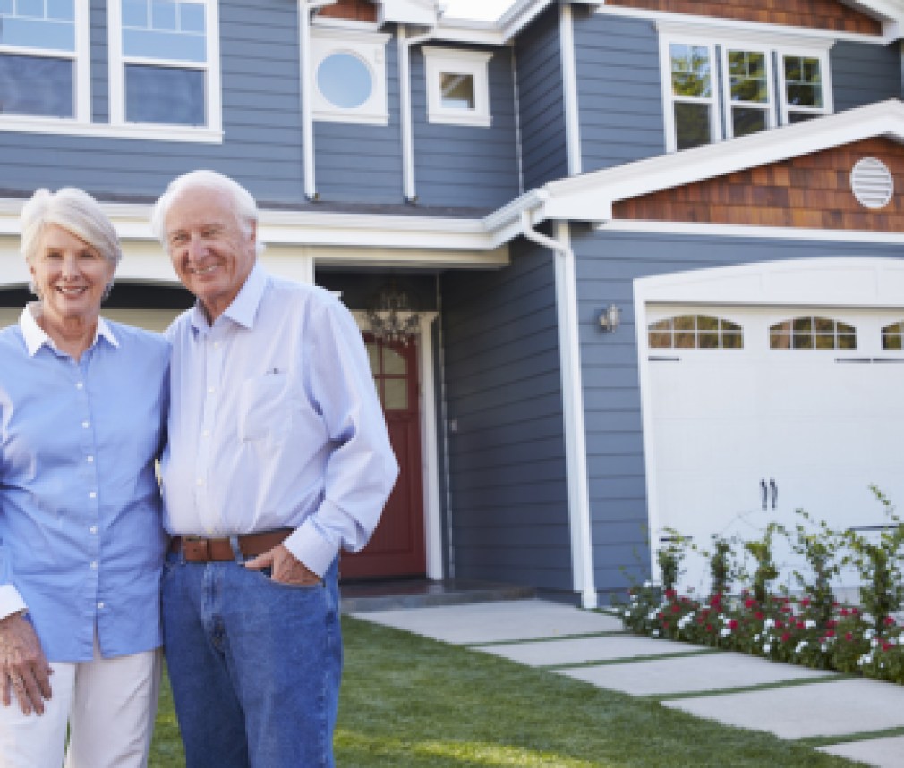 Portrait Of Senior Couple Standing Outside House