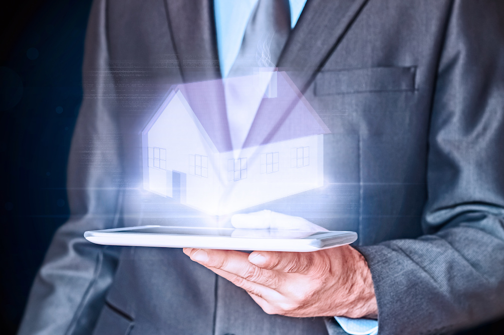 Businessman holding a virtual house. Virtual Holographic House. Business, mortgages and families concept