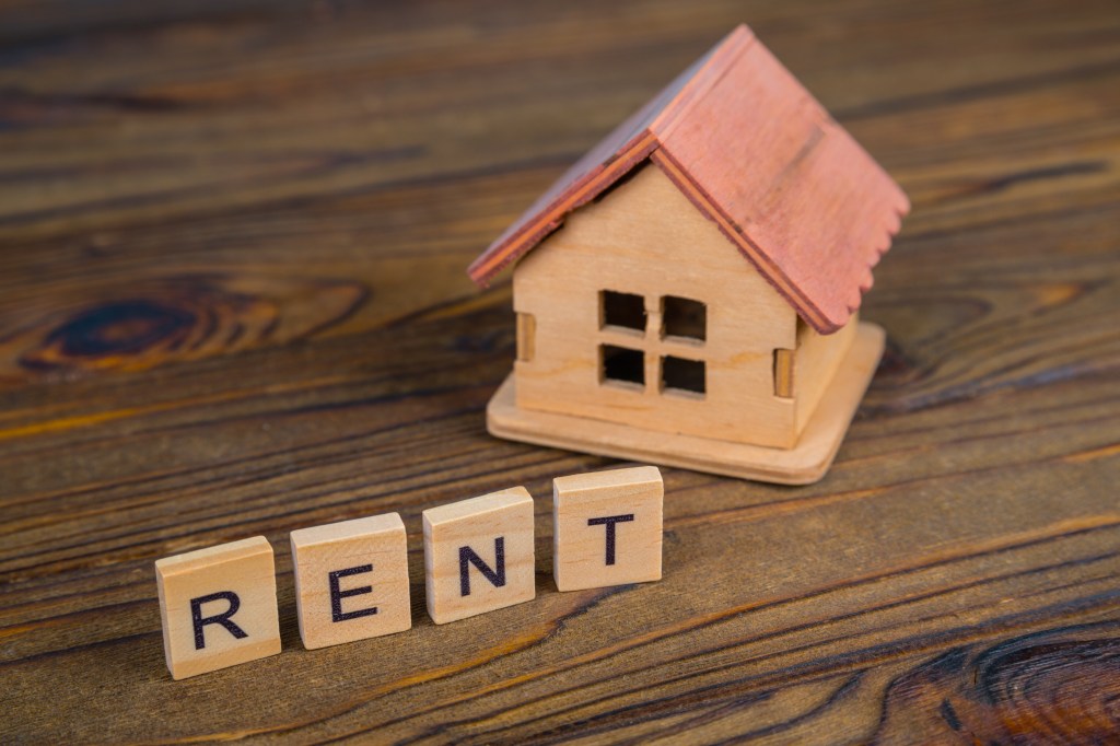 Concept rental house. Wooden house and text on the cubes Rent.