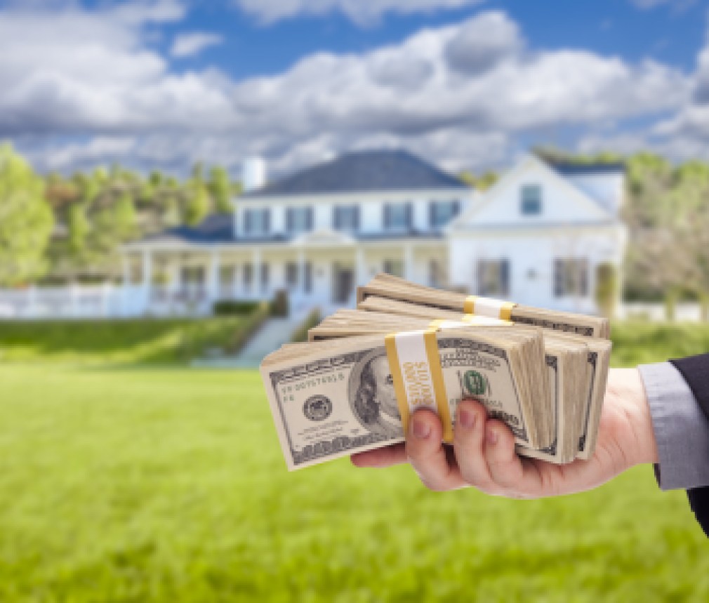 Handing Over Cash For House in Front of Beautiful New Home.