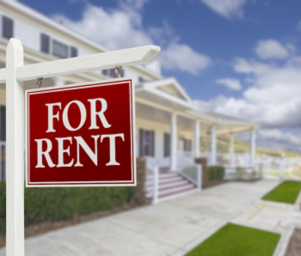 Red For Rent Real Estate Sign in Front of Beautiful House.