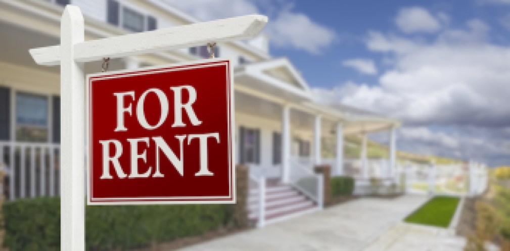 Red For Rent Real Estate Sign in Front of Beautiful House.