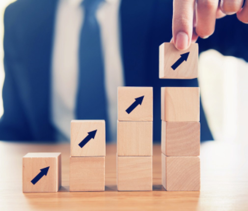 Business concept growth success process, Close up Businessman hand arranging wood cube with arrow stacking as step stair.