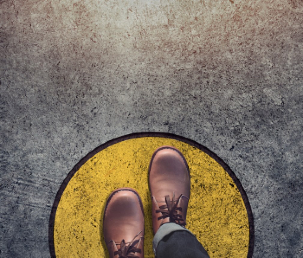 Comfort Zone concept, Male with leather shoes steps over circle line to outside bound, Top view and Dark tone, Grunge Dirty Concrete Floor as Background