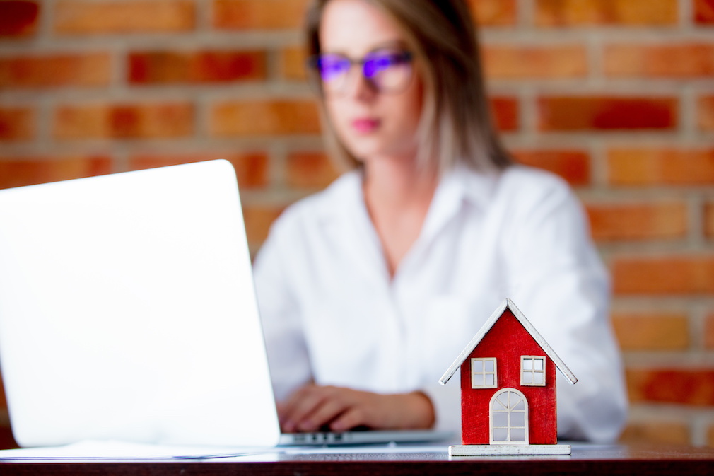 realtor with laptop computer and toy house