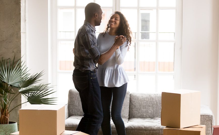 Happy African American couple dancing after moving