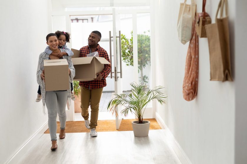 Family with cardboard boxes entering their new home