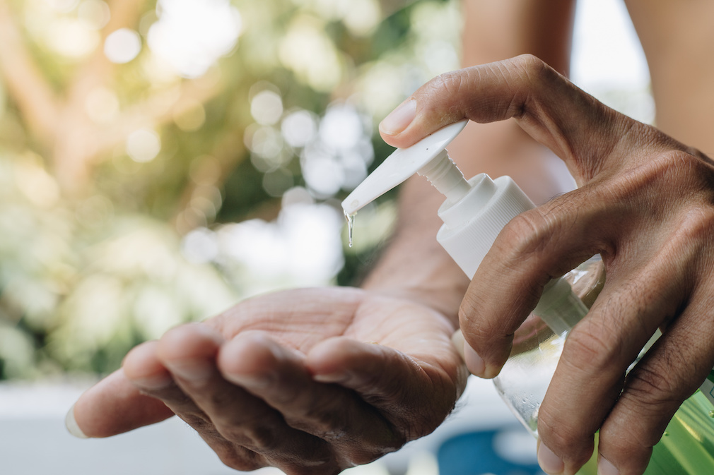 Close Up man using a hand sanitizer