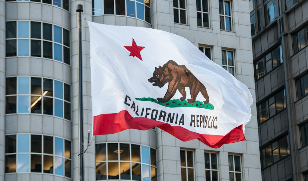 California Republic flag with grizzly bear raised in city downtown