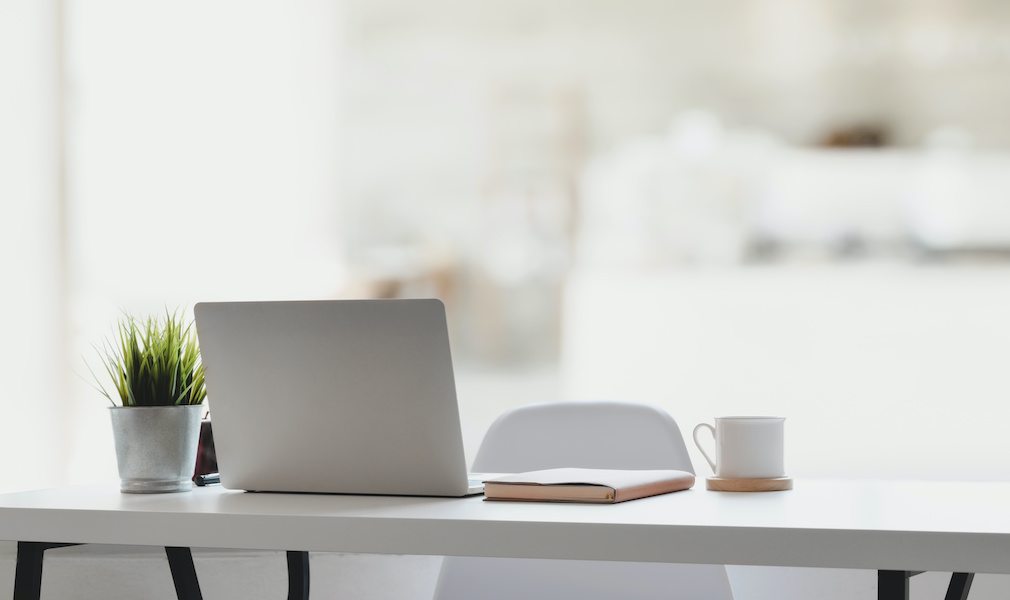 Comfortable workplace with laptop computer, coffee cup and office supplies