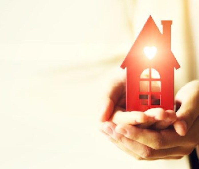 Female hand holding house key, real estate agent. Property insurance, security and cozy home concept. Copy space. Banner