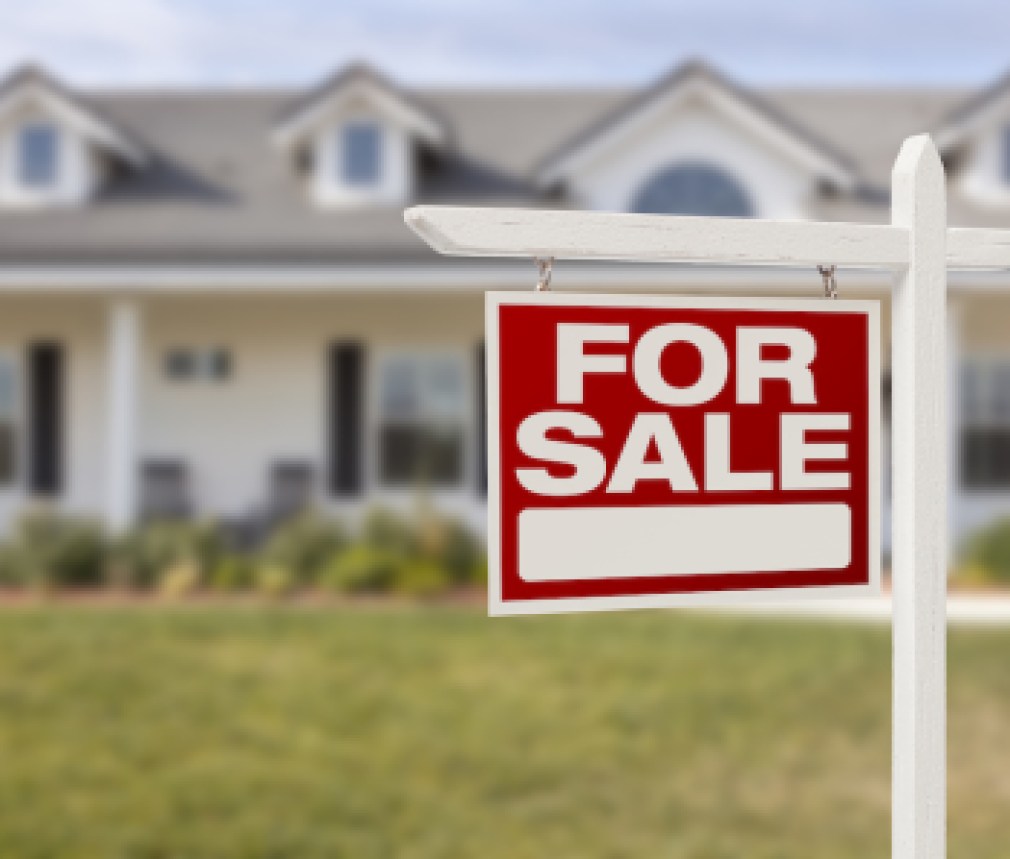 Red For Sale Real Estate Sign in Front of Beautiful New Home.