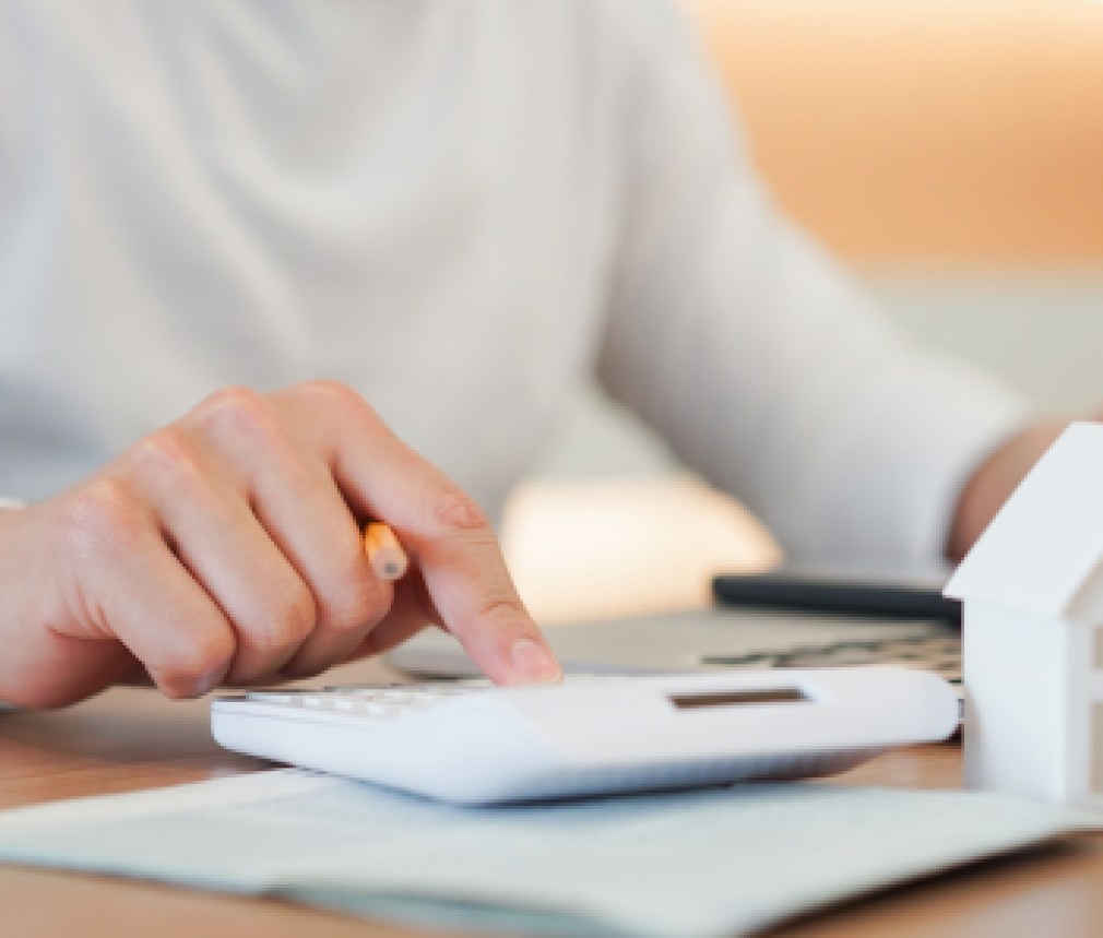 close up young man hand press on calculator to check and summary expense of home loan mortgage for refinance plan , people lifestyle concept