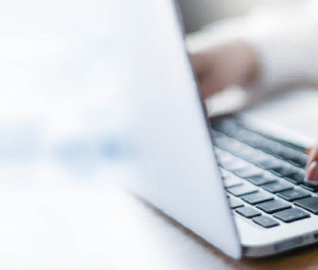 Business woman working on modern computer banner or panorama. Person buying online at internet. Laptop focused on keyboard detail with blur hand. copy space for text.