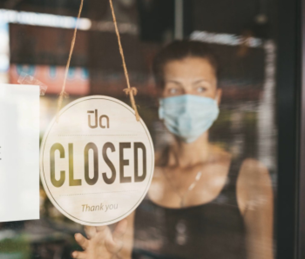 Store Owner in medical mask closed restaurant for quarantine