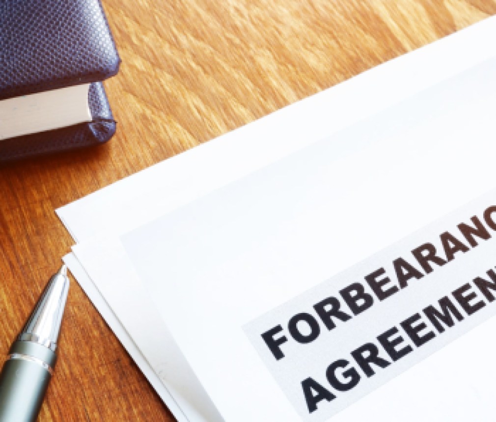 Forbearance agreement papers with pen and notepad.