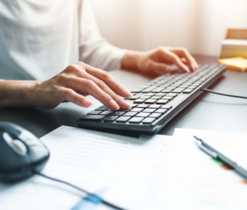 Business woman hand with computer mouse and keyboard on table at office