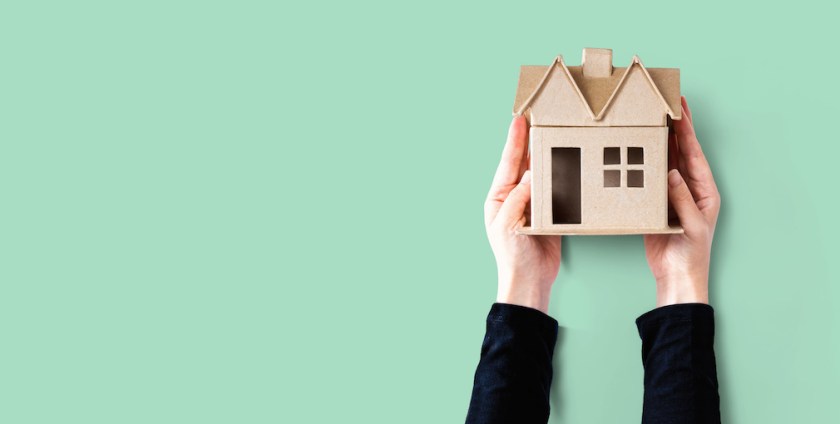 Woman holding a cardboard house