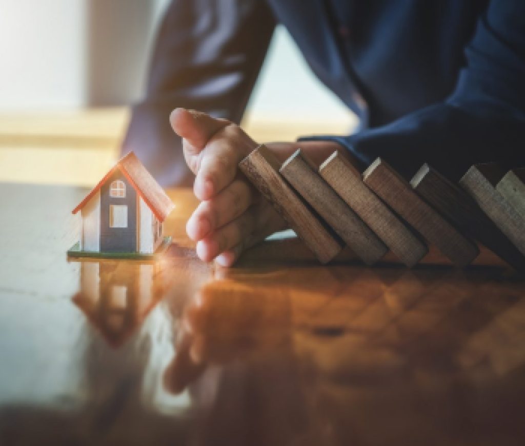 Business risk control Real estate concept,  Businessman protect wooden block fall to planning and strategy in risk estate to business Alternative and prevent. Investment Insurance Business.