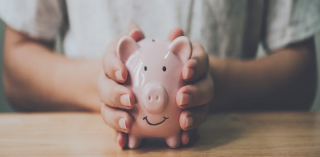 Panoramic image, Man hand holding piggy bank on wood table. Save money and financial investment