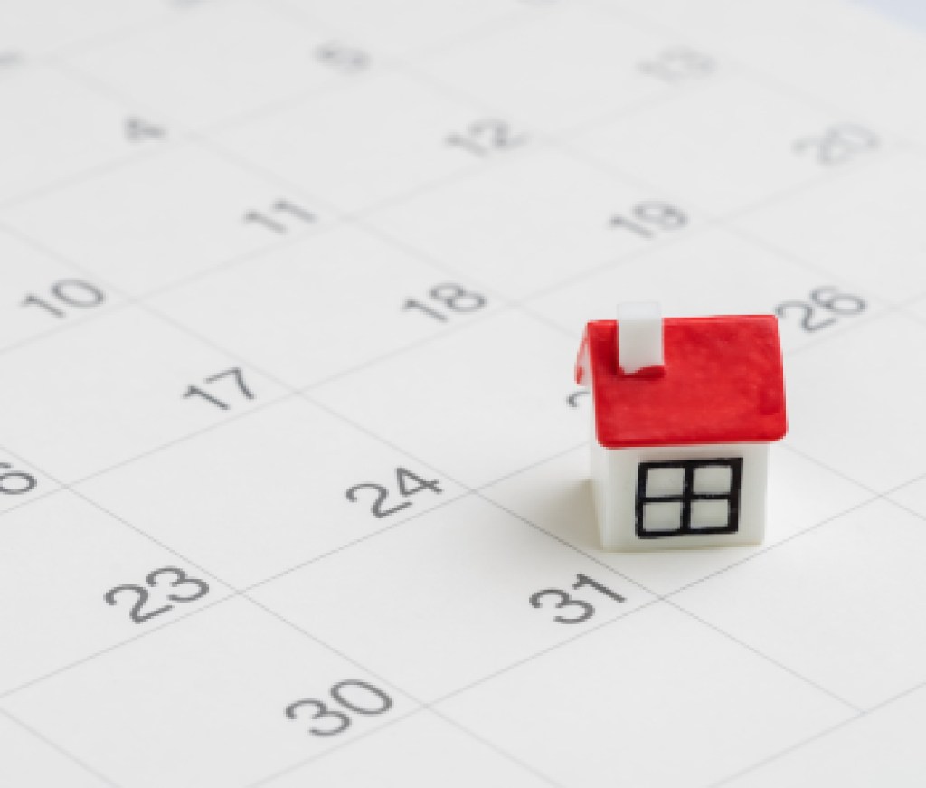 Housing, property or real estate or mortgage payment concept, miniature house with red roof on the end of month 31th date white clean calendar