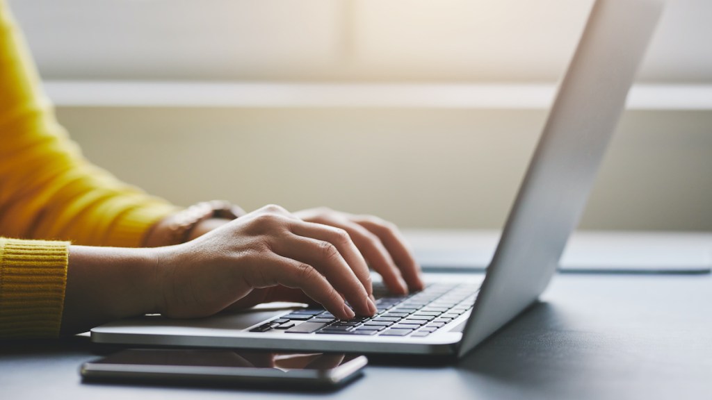 Close up of female hands while typing on laptop