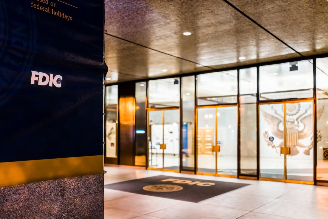 Washington DC, USA - December 28, 2017: FDIC United States Federal Deposit Insurance Corporation sign on wall of building with logo on 17th street in evening night, entrance doors