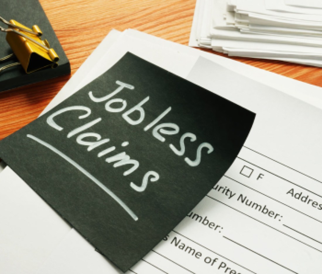 Jobless claims memo stick and pile of documents.