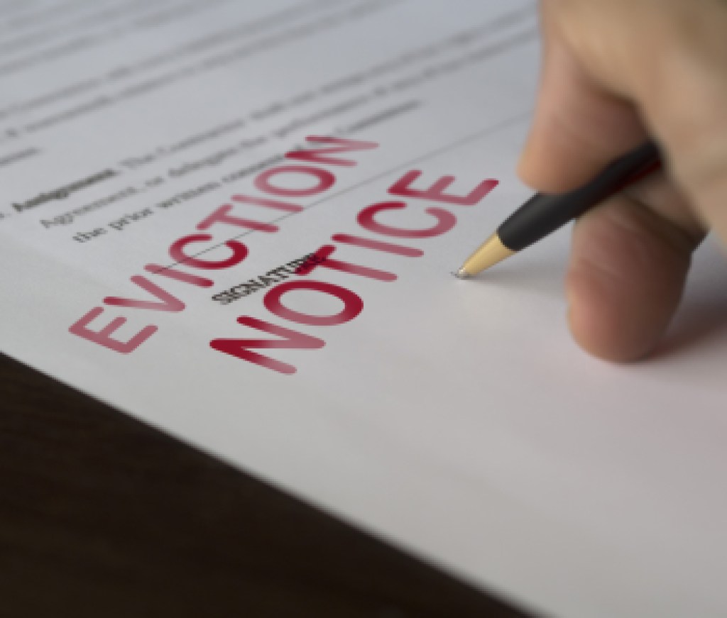 Man signing signing an eviction notice to a defaulting renter in due to missed rent in recession