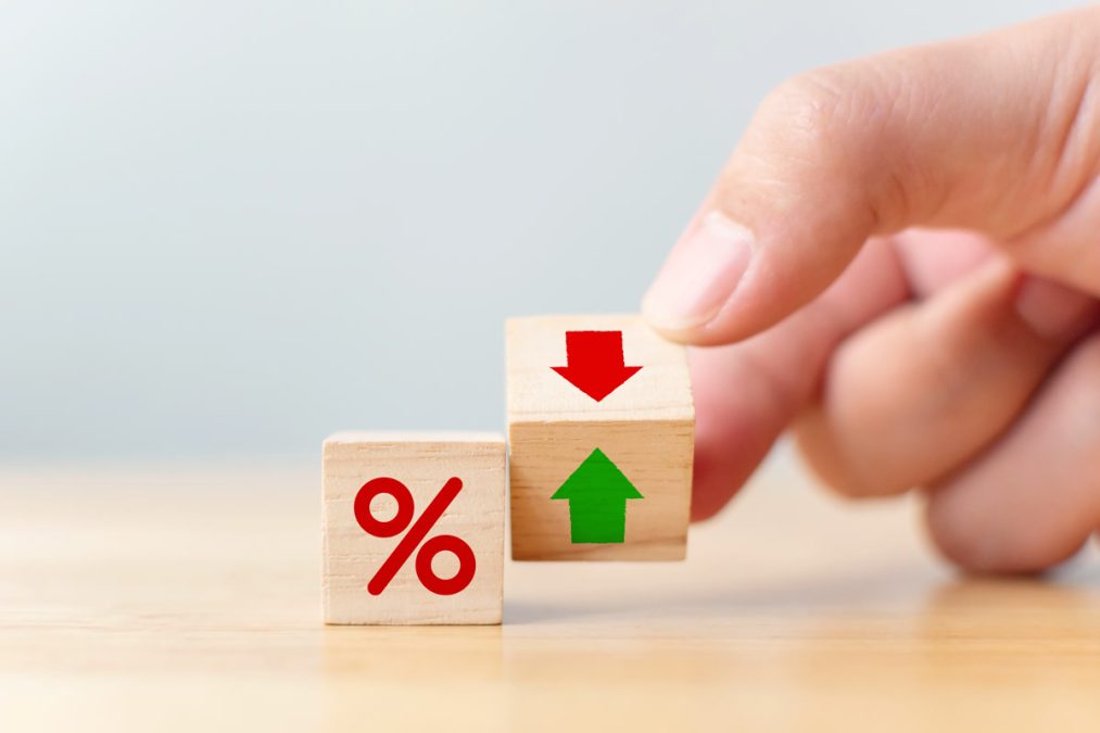 Interest rate financial and mortgage rates concept. Hand flip wood cube change arrow down to up