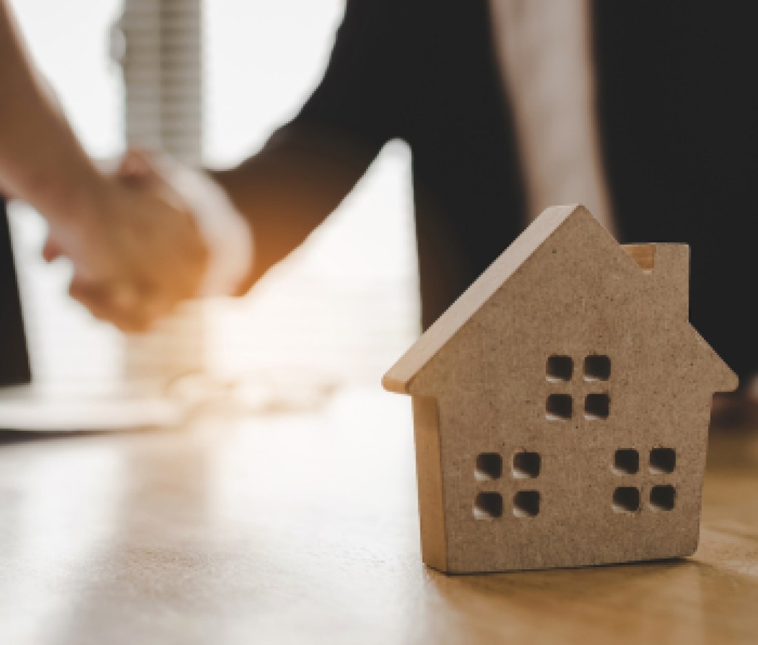 real estate broker manager hand shake to customer after signing contract for buying house in estate agent office behind House model, investment, home loan contract, buy and sell house concept