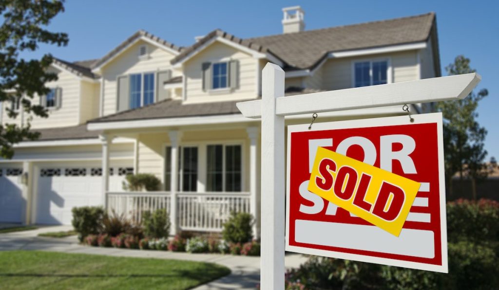 Sold Home For Sale Sign in Front of Beautiful New House.