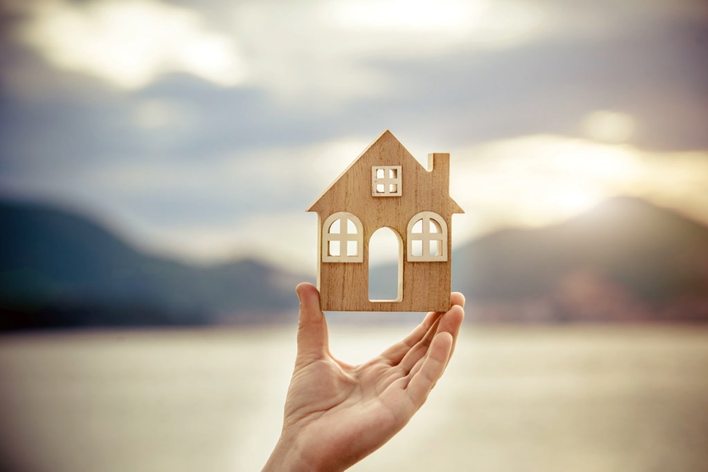 Girl holding the symbol of the house over the sea