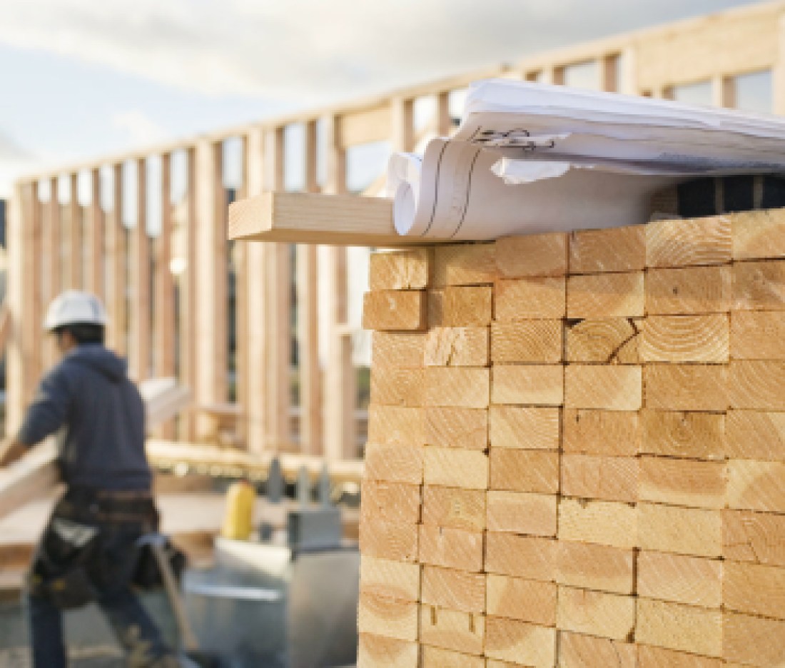 Stacked Lumber and Blueprints at a Construction Site