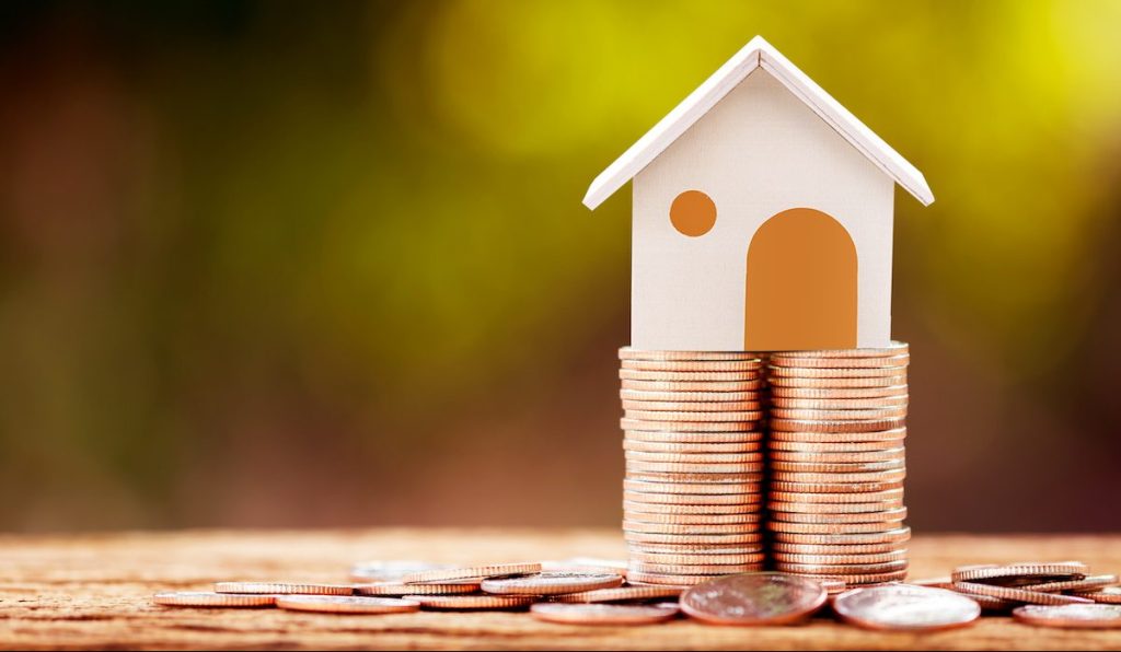 Loan or saving money for buy a house and real estate for family concept, Home model put on the stack coin tower with growing business investment in the in the public park.