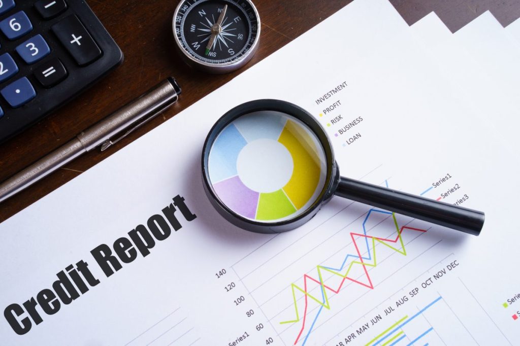 Magnifying glass on colourful pie chart with "Credit report" tex