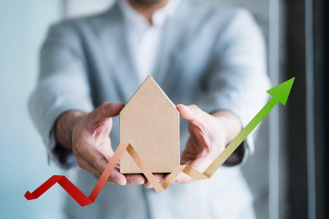 financial asset business concept with businessman hold house model with financial chart graph symbol