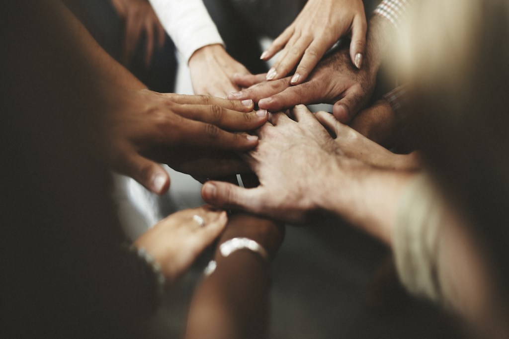 People with joined hands as a team