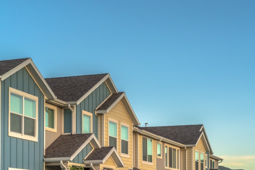 Exterior of upper storey of townhomes with blue sky background on a sunny day