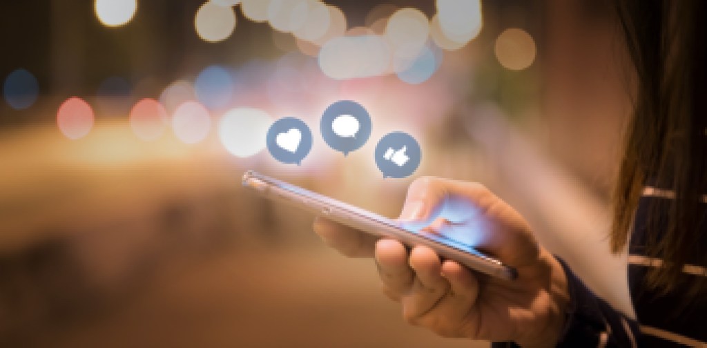 Woman hands using mobile smartphone in the street with icon social media and social network.