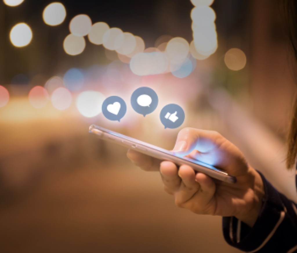 Woman hands using mobile smartphone in the street with icon social media and social network.