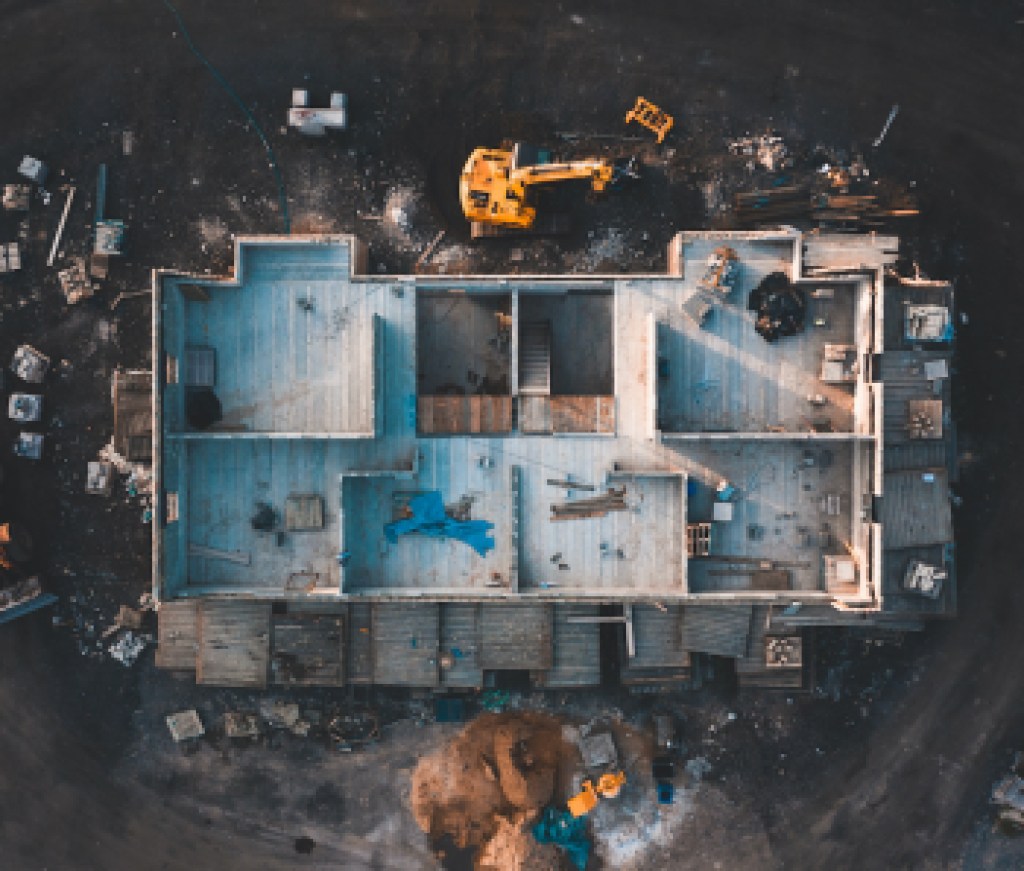 Aerial birds eye image of the frame of a house being built on a construction site at sunset - Wooden floor and walls are visible