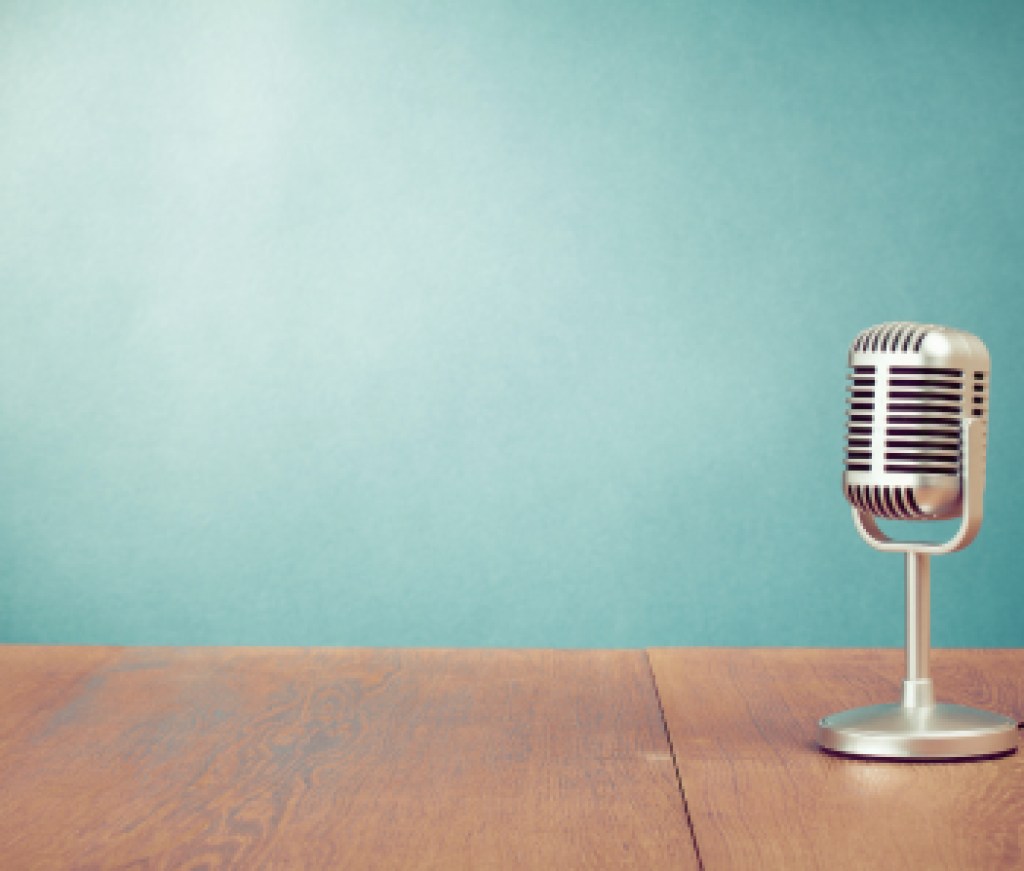 Retro style microphone on table in front aquamarine wall