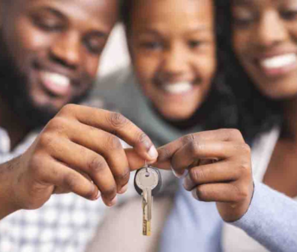 Happy african american family holding keys from their new home