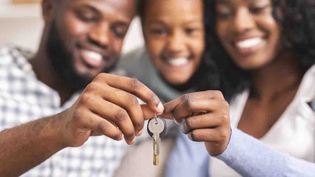 Happy african american family holding keys from their new home