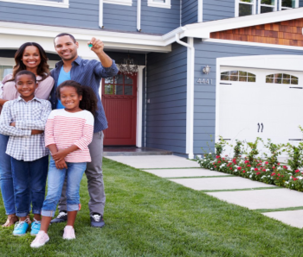 Happy black family standing outside their house, dad holding the key