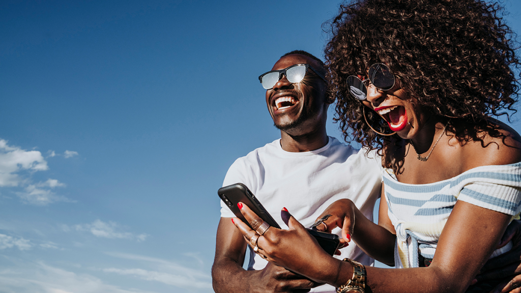 Part-time real estate agent: young woman with a friend receives text on her phone that she's landed her first client